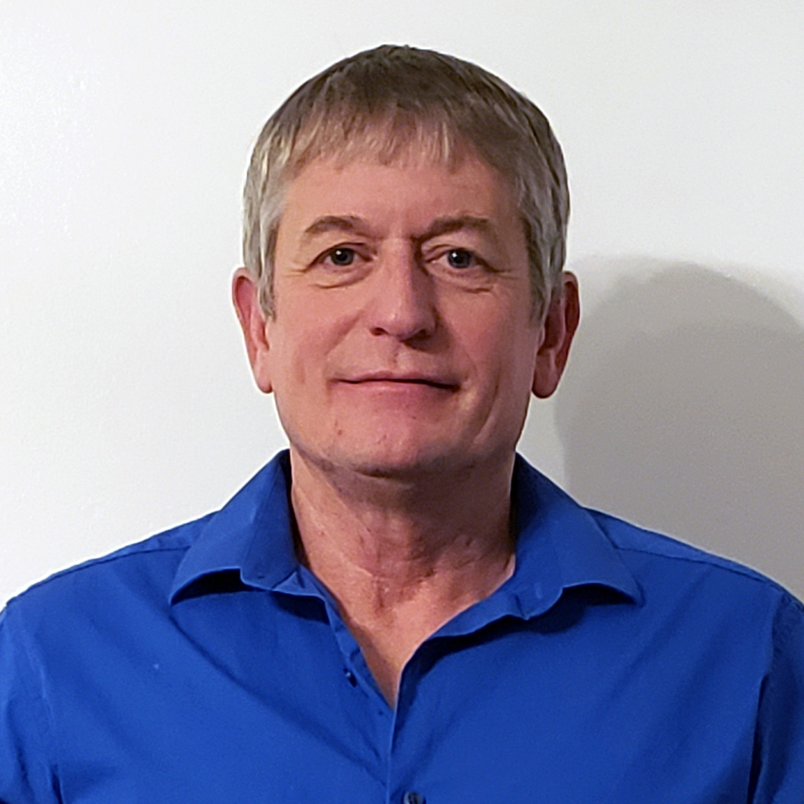 Headshot of Russ Hearn in a blue button down shirt