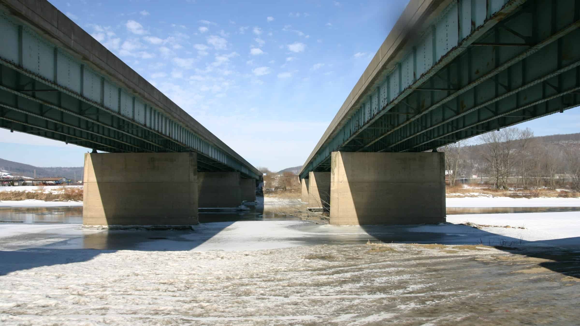 The two Interstate 81 bridges extend over an icy Susquehanna River.