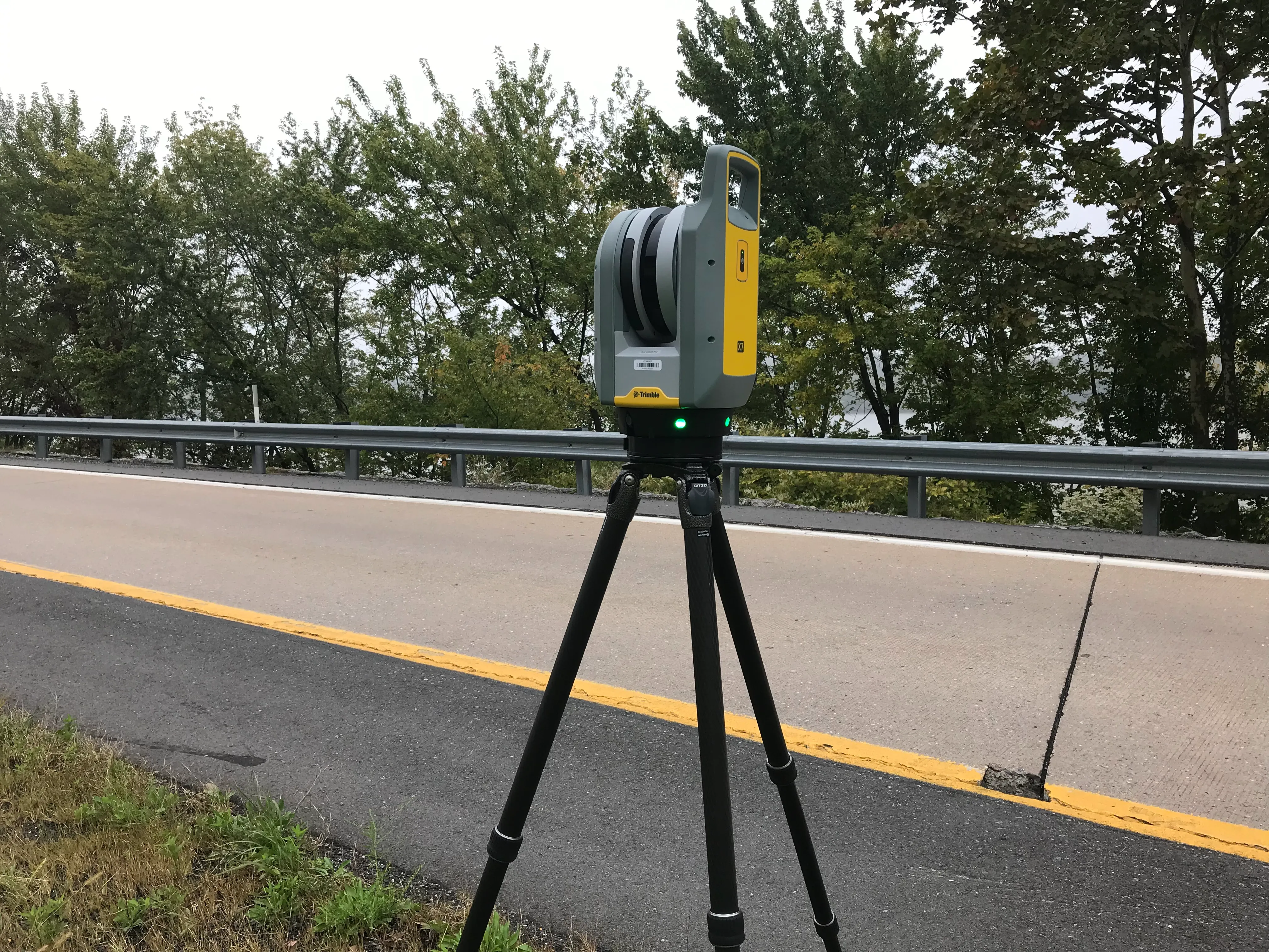 An image of a lightweight, three-dimensional laser scanner sitting along an on-ramp.